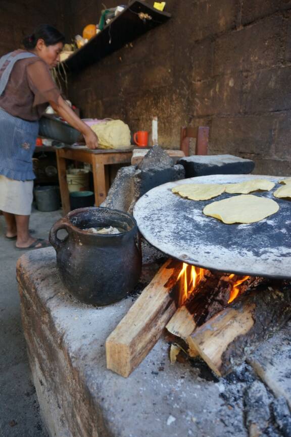 Fig. 1 :  L’élaboration de tortillas au foyer à partir de masa fraîche (maïs broyé), visible en arrière-plan, 2022. Photo de Morgan Jenatton